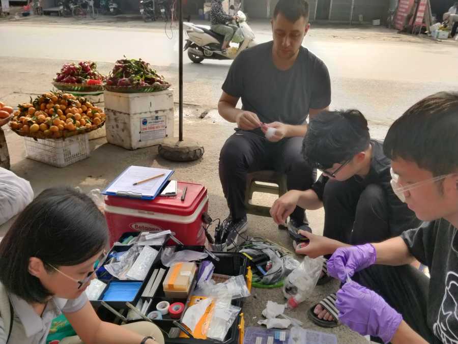 DeltAs crew collecting water samples next to fruit stand